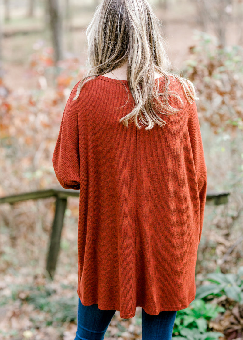 Back view of Blonde model wearing deep rust long sleeve top.