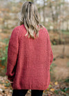 Back view of Blonde model wearing a rust cable knit cardigan