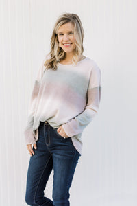 Blonde model wearing an ombré long sleeve sweater. 