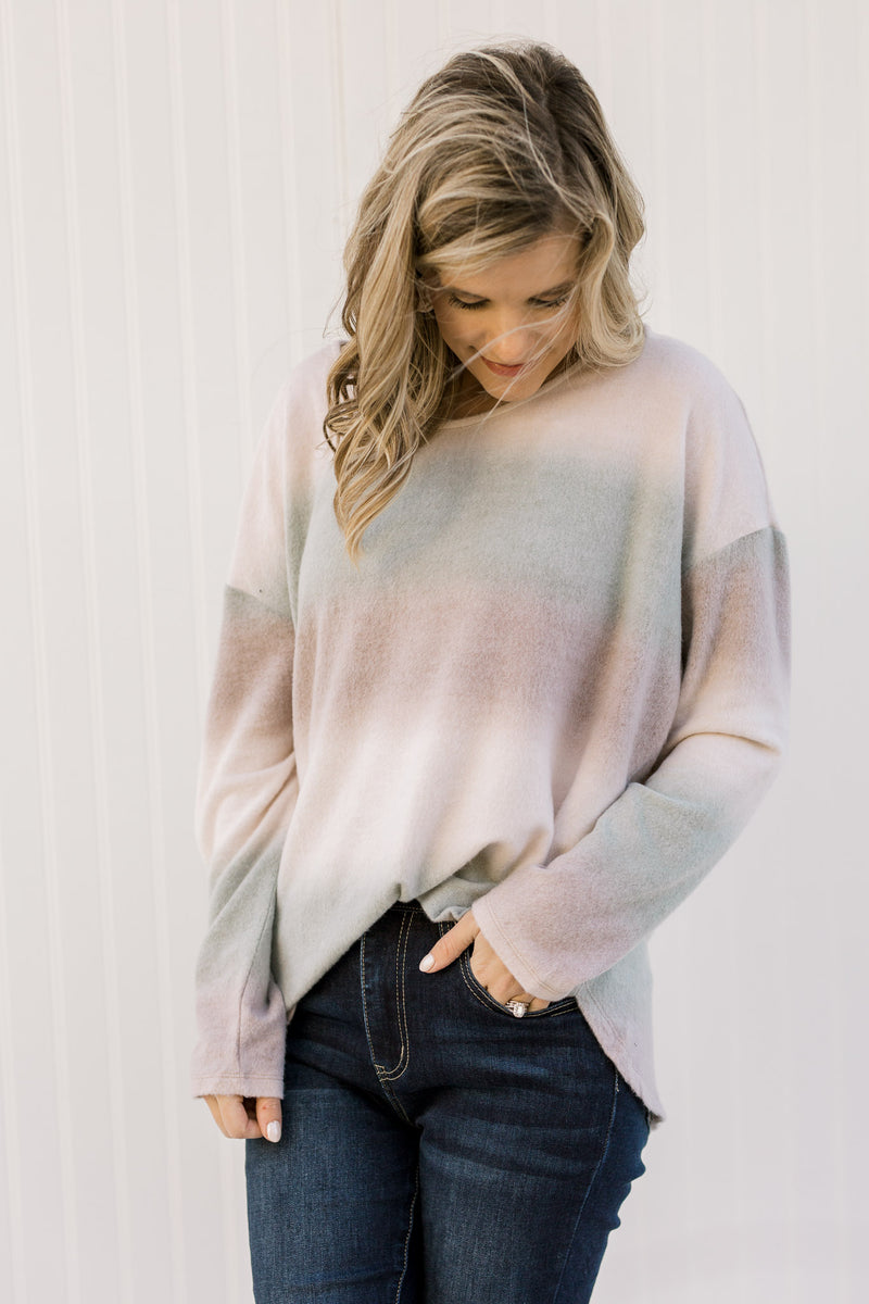 Blonde model wearing an ombré long sleeve sweater with jeans. 