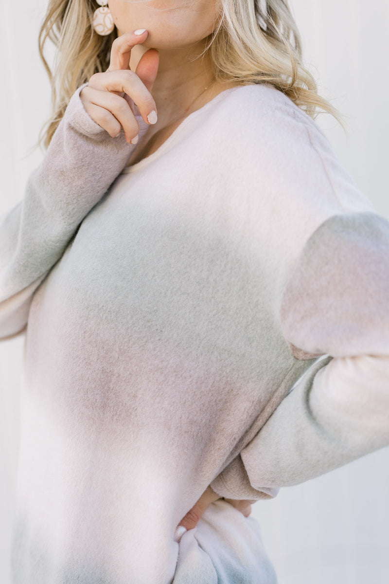 Close up view of Blonde model wearing an ombré long sleeve sweater. 