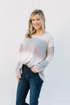 Blonde model wearing an ombré long sleeve sweater tucking into jeans. 