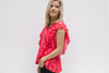 Side view of Blonde model wearing a bright pink top with capped sleeves.