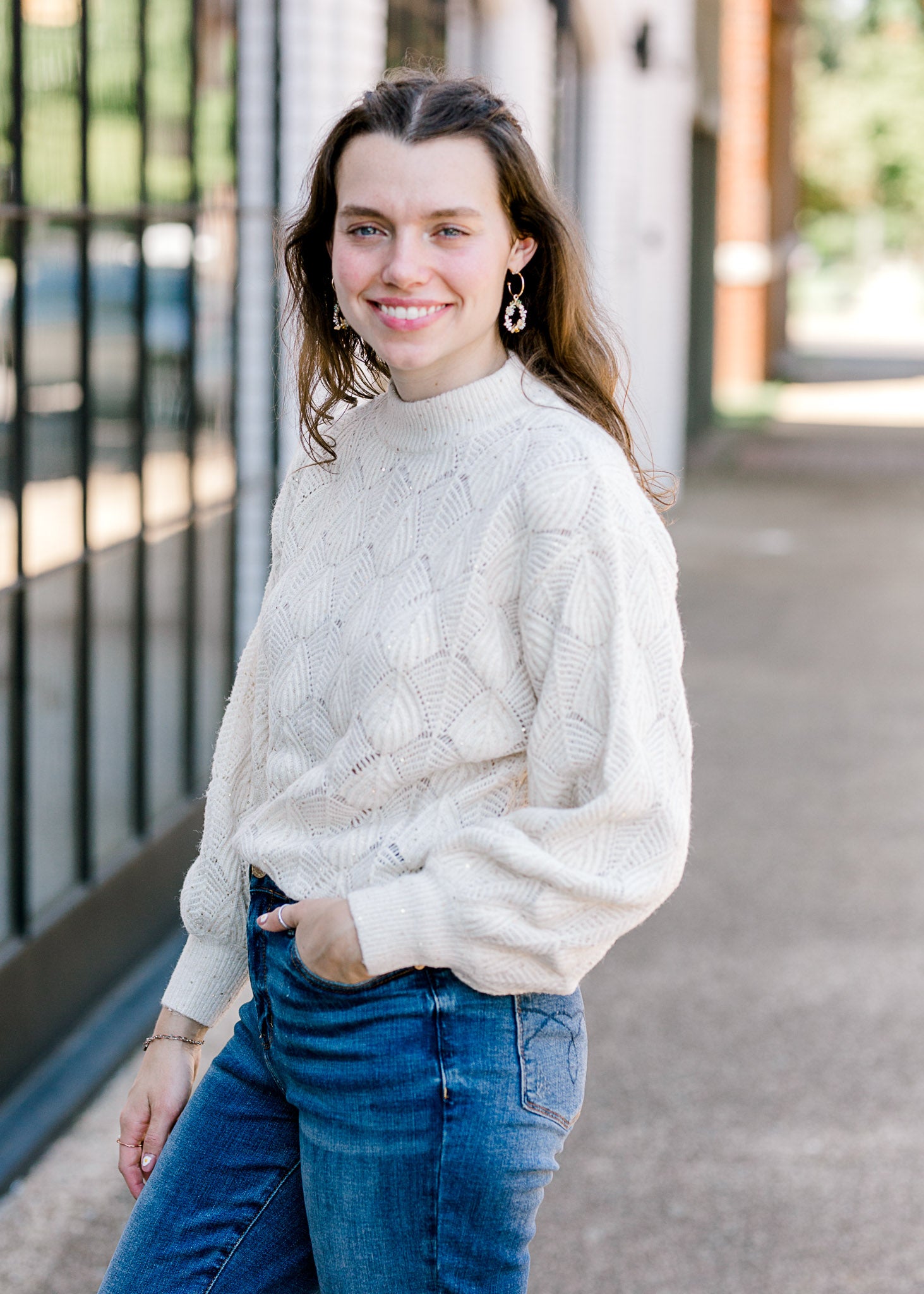 Brunette model wearing cream sweater.