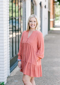Blonde model wearing burnt coral dress.