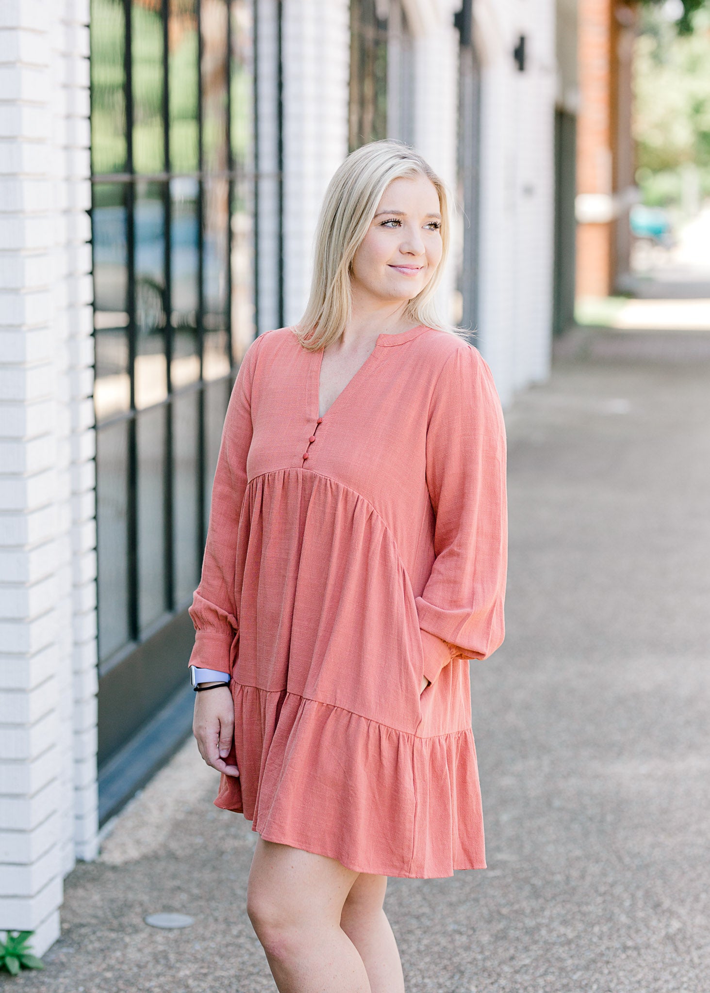 Blonde model wearing tiered, burnt coral dress.