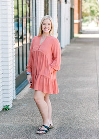 Blonde model wearing burnt coral dress with sandals.