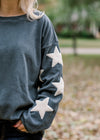 Sleeve detail of cream stars on slate blue sweater.