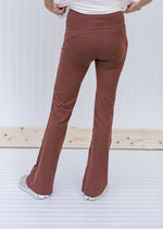 Back view of Blonde model wearing brownish flared yoga pants.