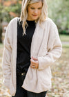 Blonde model is soft cream cardigan.