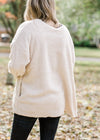Back view of Blonde model is soft cream cardigan.