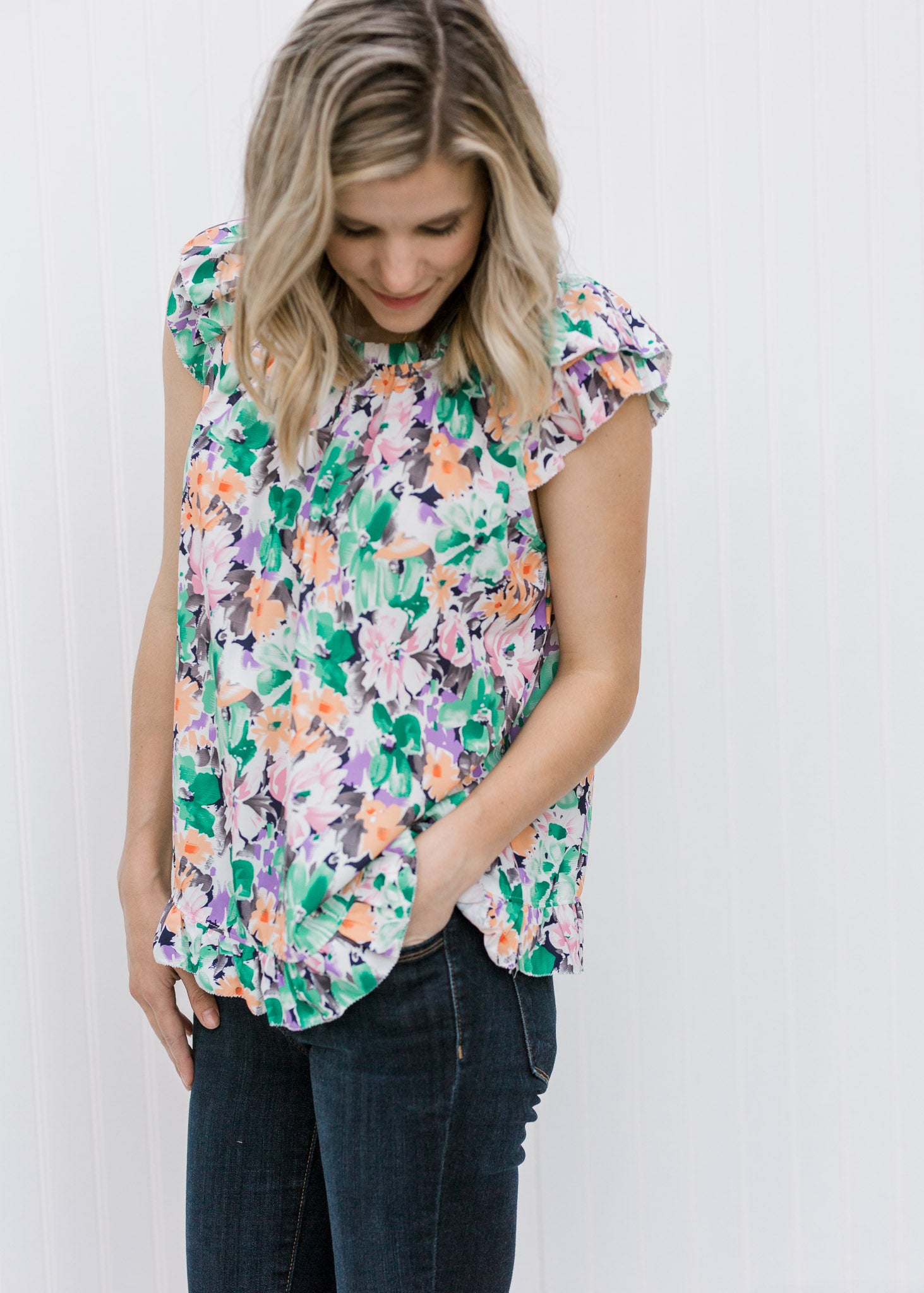 Blonde model wearing a abstract floral top. 