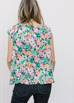 Back view of Blonde model wearing a abstract floral top.