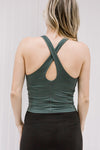 Back view of Blonde model wearing a hunter green workout top with a keyhole. 