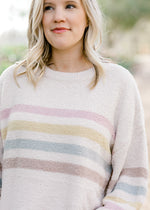 Close up of stripes on cream sweater.
