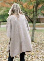 Back view of Blonde model wearing taupe poncho.