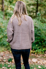 Back view of Blonde model wearing taupe sweater.