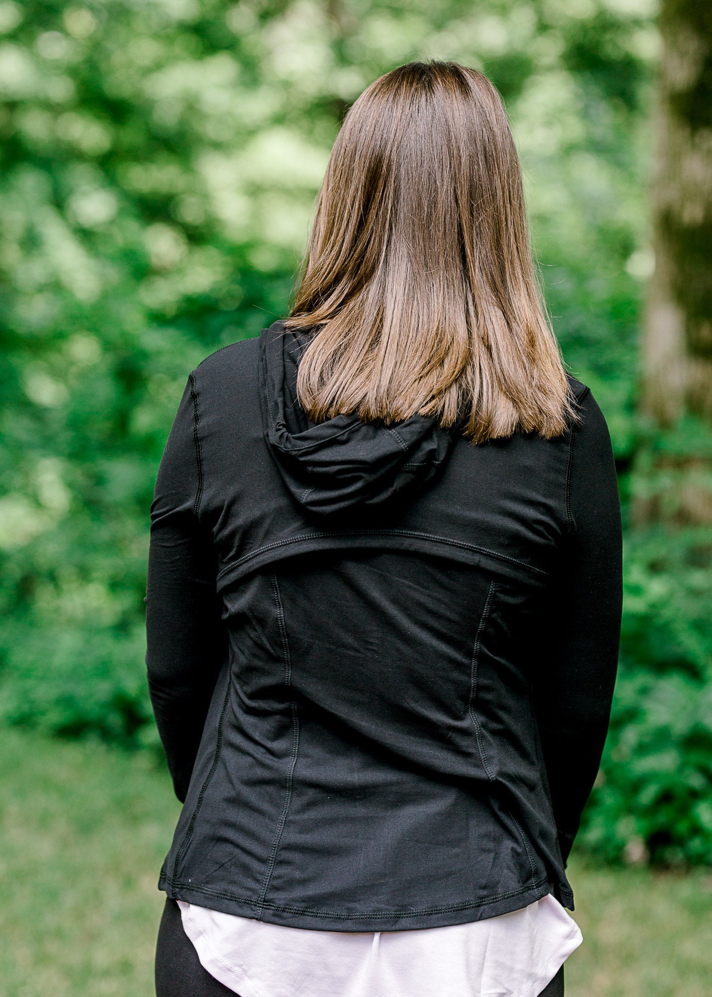 Back view of Brunette model wearing front zip athleisure jacket.