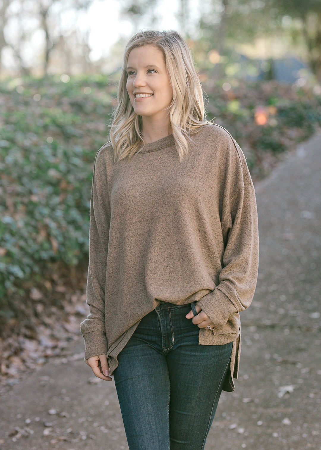 Blonde model wearing heathered light brown sweater. 
