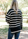 Back view of Blonde model wearing black and white striped sweater.