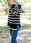 Blonde model wearing black and white striped sweater with jeans.
