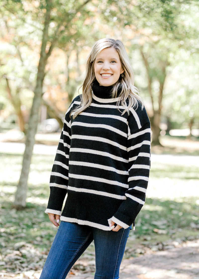 Blonde model wearing black and white striped sweater.