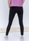 Back view of Model wearing full length black leggings.