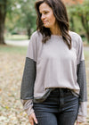 Close up view of Brunette model wearing ash and charcoal two toned top.