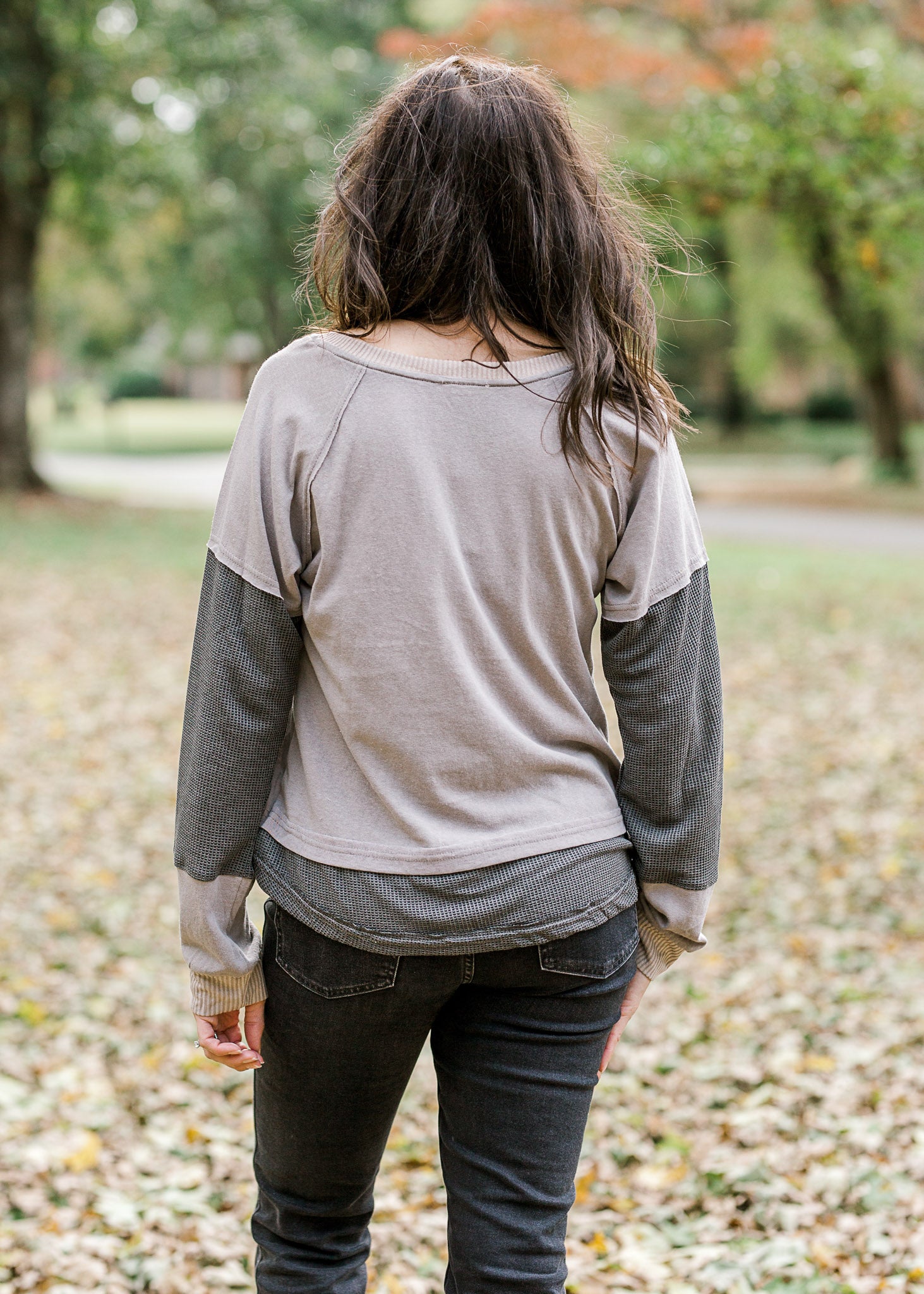 Back view of Brunette model wearing ash and charcoal two toned top.