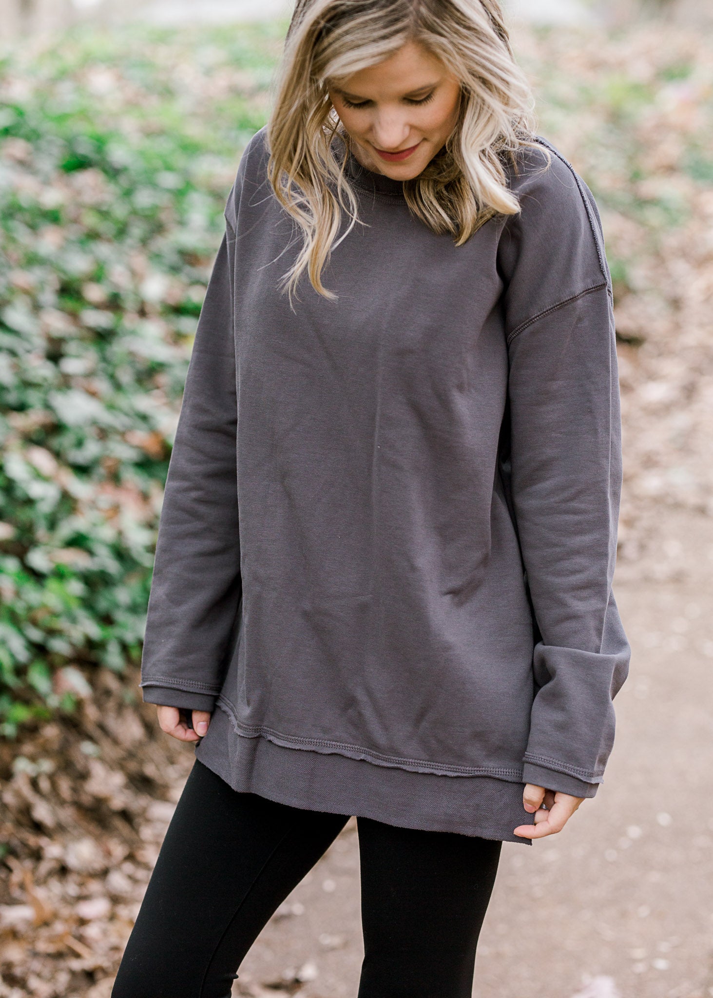 Blonde model wearing charcoal long sleeve top.