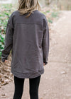 Back view of Blonde model wearing charcoal top with leggings.