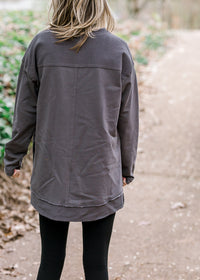 Back view of Blonde model wearing charcoal top with leggings.