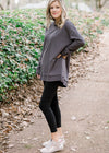 Blonde model wearing charcoal top with split hem.