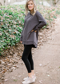 Blonde model wearing charcoal top with split hem.