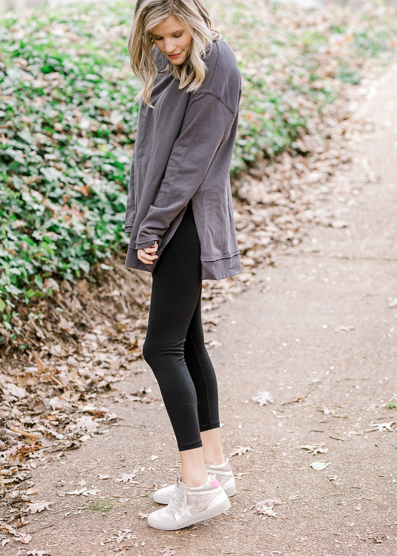 Blonde model wearing charcoal top with leggings and tennis shoes.