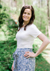 Brunette model wearing short sleeve ivory body suit.