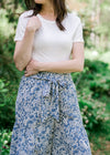 Front view of Brunette model wearing short sleeve ivory body suit.