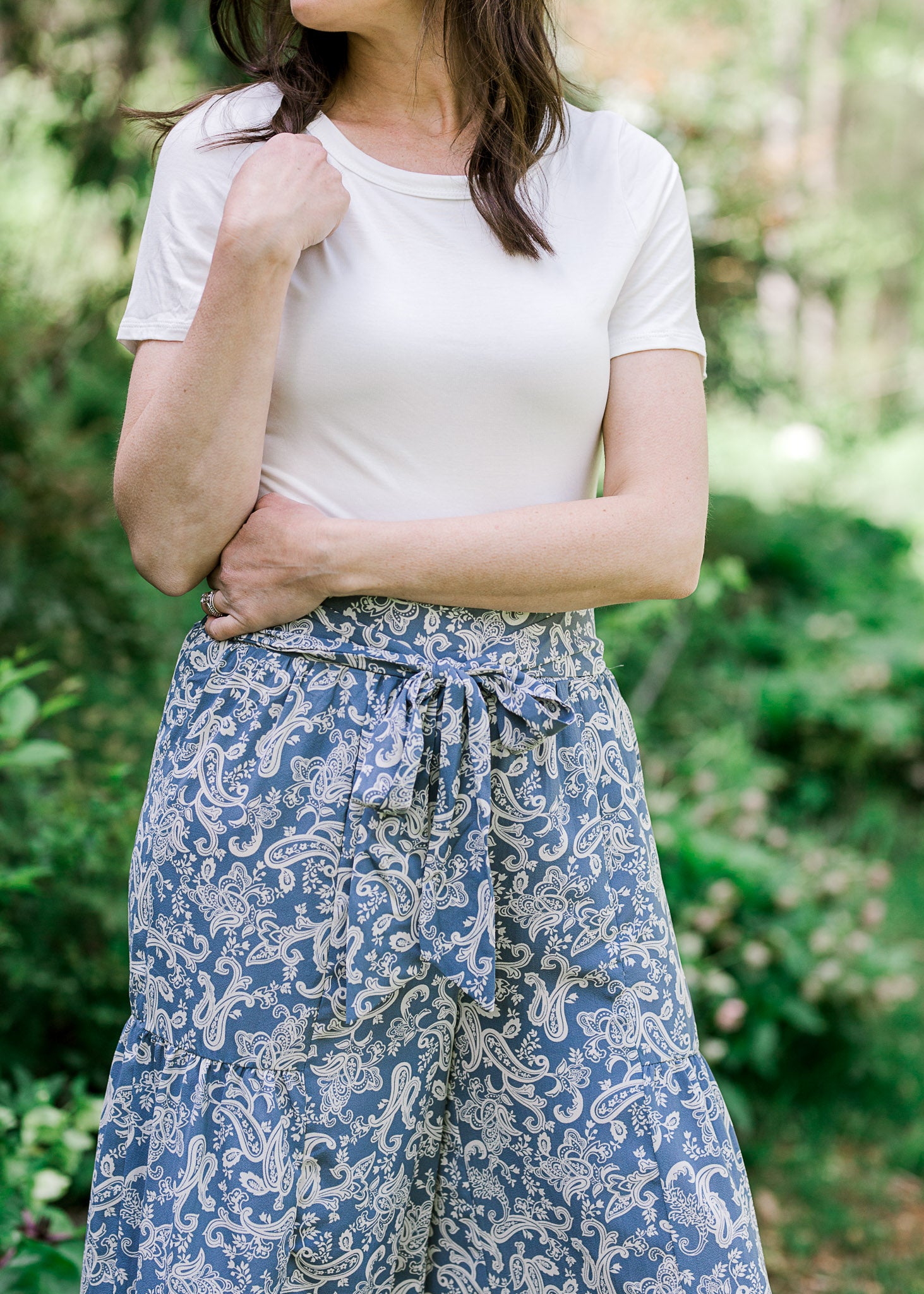 Front view of Brunette model wearing short sleeve ivory body suit.