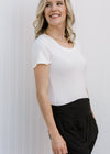 Side view of Blonde model wearing white tee shirt bodysuit. 