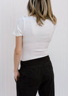 Back view of Blonde model wearing white tee shirt bodysuit.