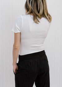 Back view of Blonde model wearing white tee shirt bodysuit.